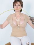Sexy ripe domme in skin-tight outfit looks menacing and appealing with her whip