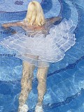 Beautiful mature housewife posing by the pool in a see through white skirt