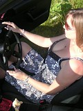 Wild brunette housewife posing in the car and showing her massive bare boobs outdoors