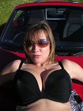 Wild brunette housewife posing in the car and showing her massive bare boobs outdoors