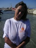 Shameless older babe soaks her white tee up to flash her big jugs at the beach