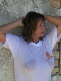 Shameless older babe soaks her white tee up to flash her big jugs at the beach