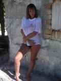 Shameless older babe soaks her white tee up to flash her big jugs at the beach