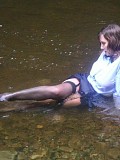 Insanely hot pictures of a horny brunette milf getting wet in the river with her stockings on