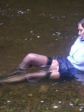 Insanely hot pictures of a horny brunette milf getting wet in the river with her stockings on