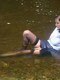 Insanely hot pictures of a horny brunette milf getting wet in the river with her stockings on