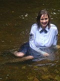 Insanely hot pictures of a horny brunette milf getting wet in the river with her stockings on