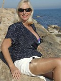 Slutty mature babe flashes her massive jugs while posing in a hot bikini on the beach